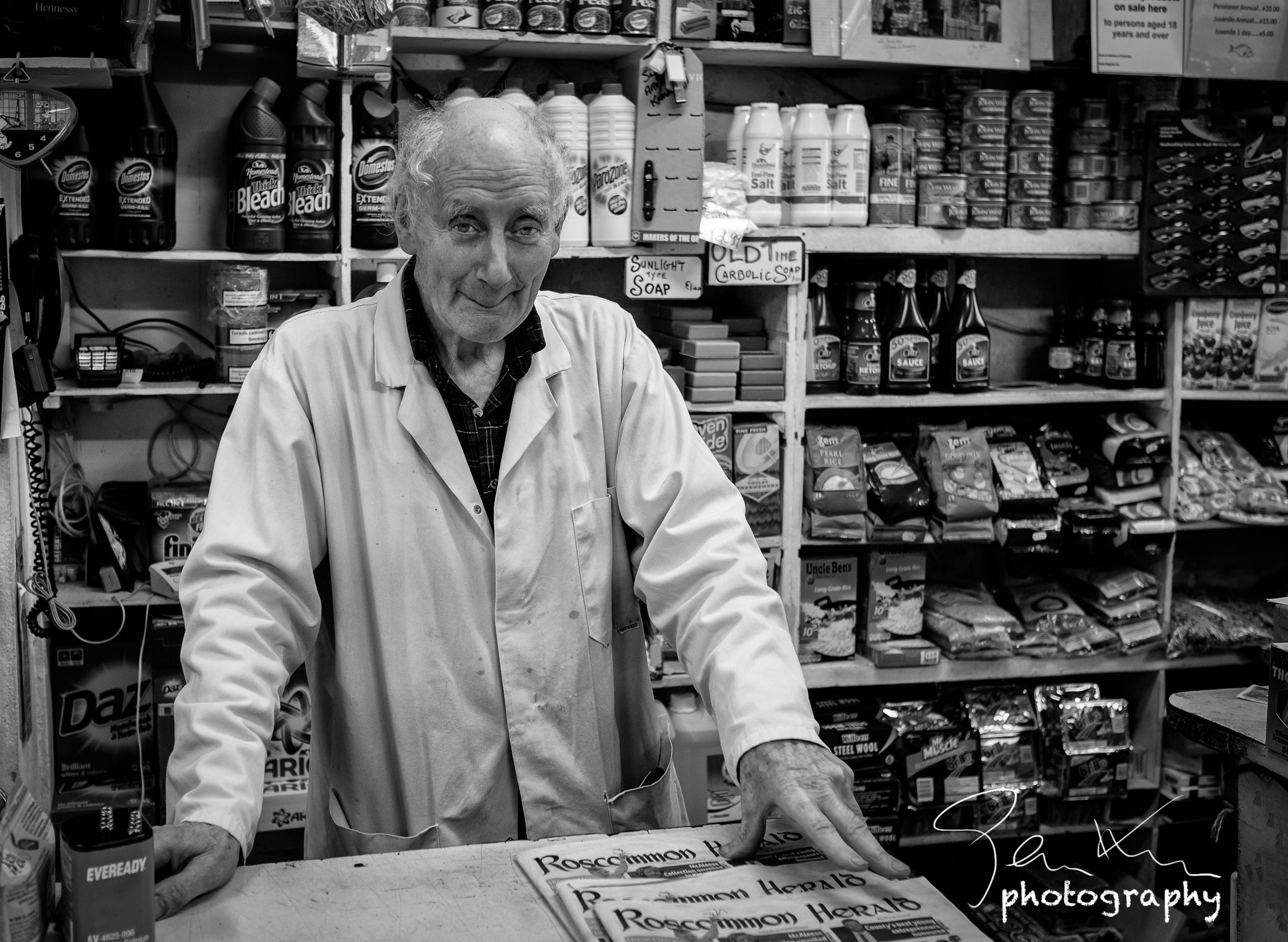 Roscommon shopkeeper with traditional overcoat
